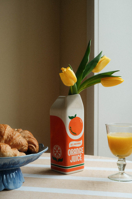 flower vase novelty design of an orange juice carton made of cermamic with white and orange design