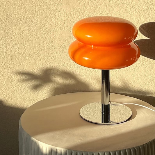 Macaron table lamp is a bauhaus, mid-century, retro inspired night lamp with options of orange, white, cream and pink. Lampshade is made of glass and frame is steel for robust quality. It offers an ambient mood at night and promotes healthy sleep cycle from harsh bright lights.
